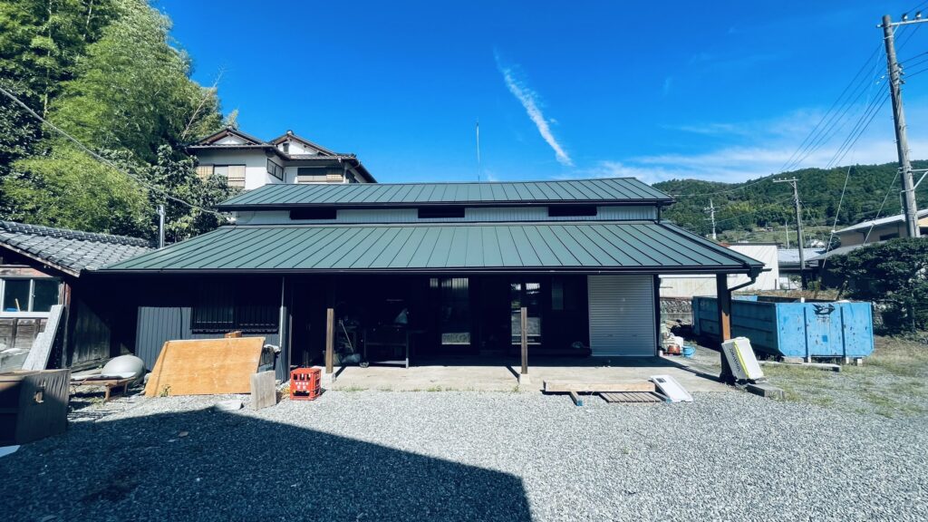 納屋リフォーム後の外観全景。ダークカラーの屋根と外壁で寺っぽい雰囲気に