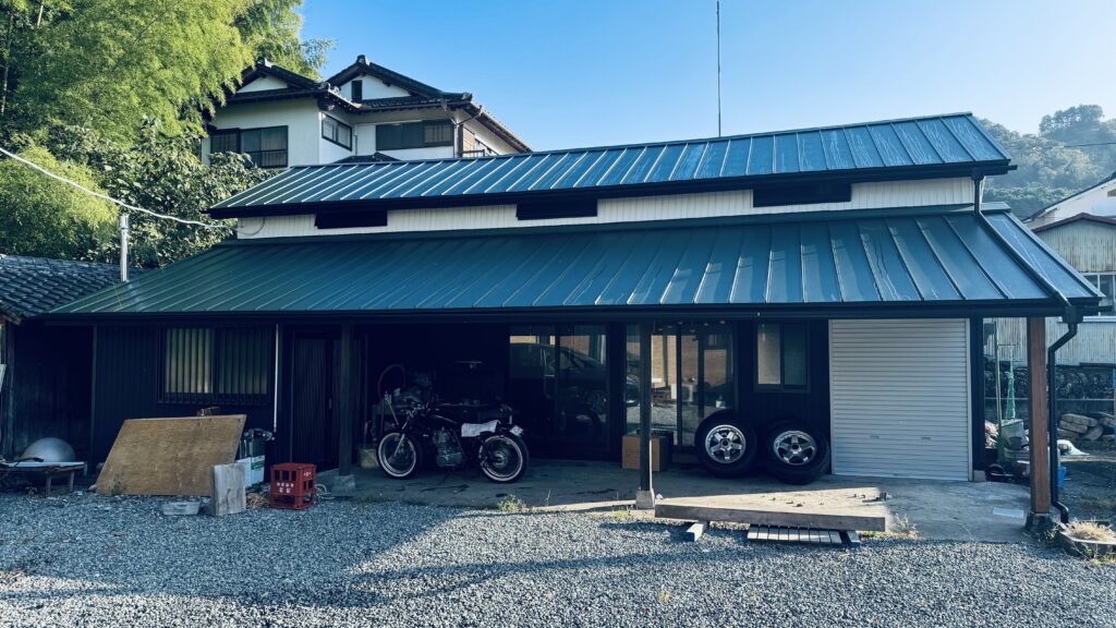 納屋リフォーム後の外観全景。ダークカラーの屋根と外壁で寺っぽい雰囲気に