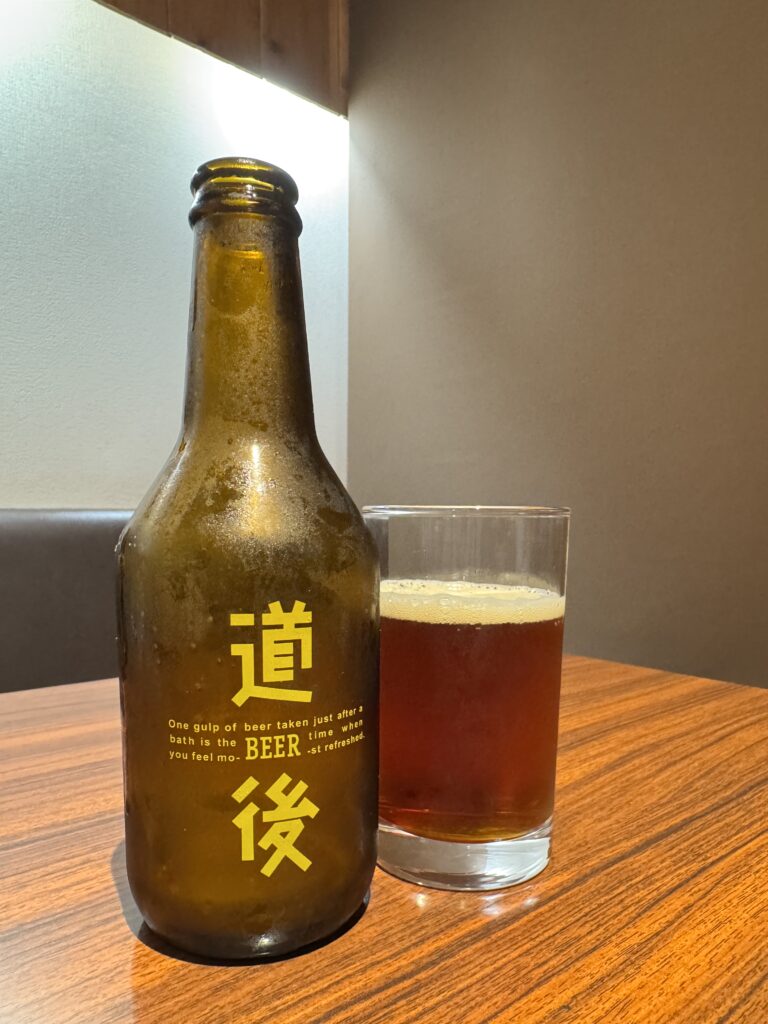 道後ビールのアンバー。ボトルとグラスのテーブルショット
