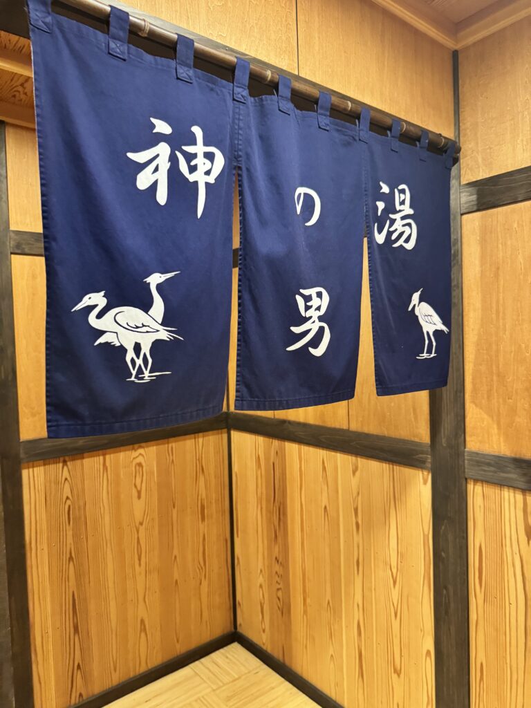 道後温泉本館「神の湯（男）」の暖簾。熱めの湯でじっくり温まる男湯入口。