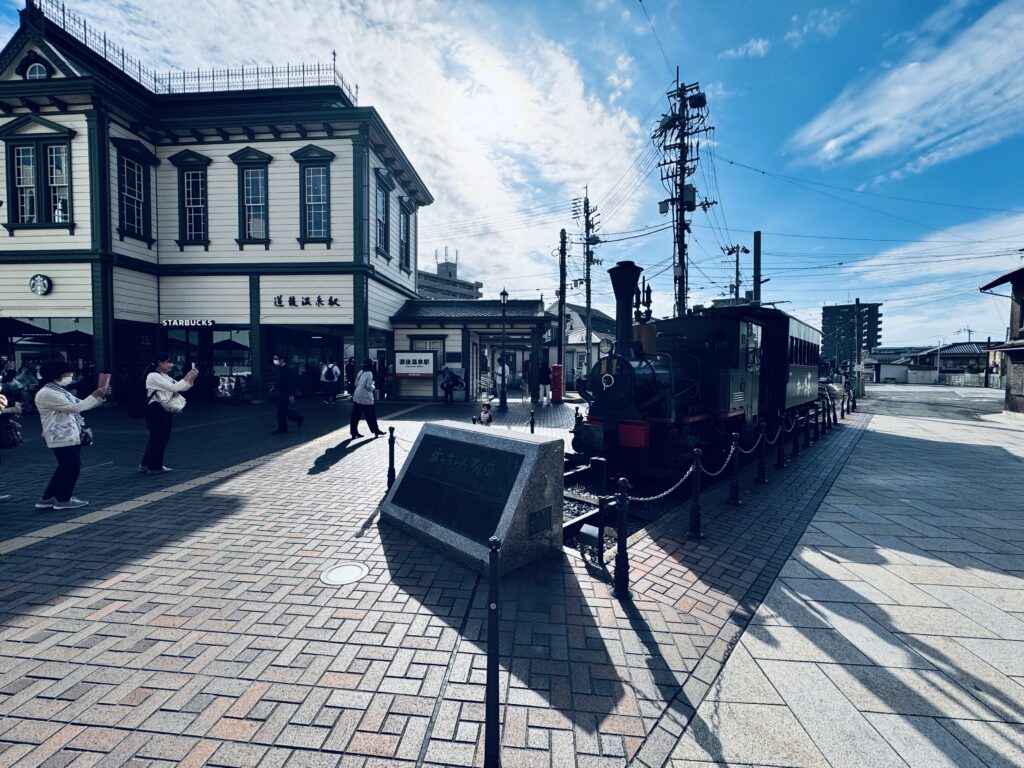 道後温泉駅前に佇む坊っちゃん列車。レトロな車体が温泉街の雰囲気に溶け込む撮影スポット。