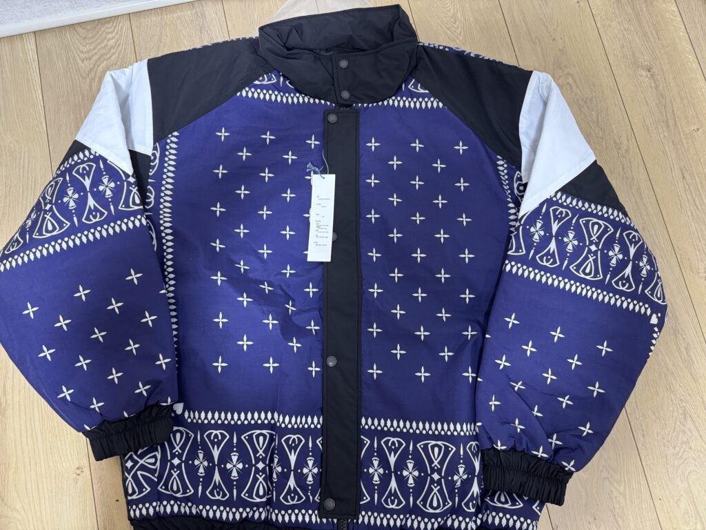 広げてみると、プリントの線の細かさと均一さが際立つ。 ネイビーのおかげで派手すぎず、むしろ“大人のストリート感”が強い印象。